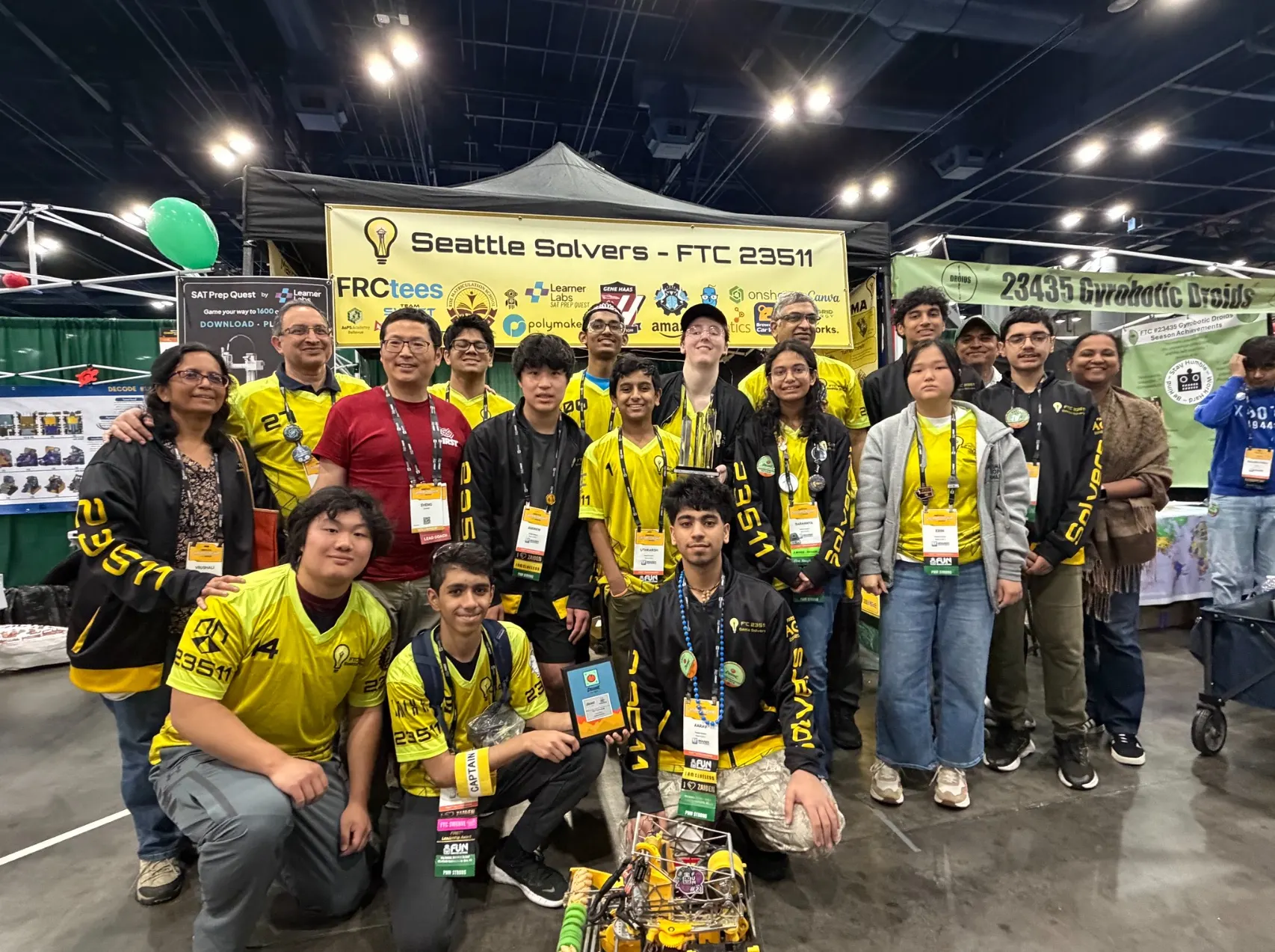 The Seattle Solvers team and mentors at their competition booth, under the team banner