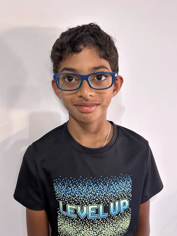 Vihaan in a black t-shirt and blue glasses